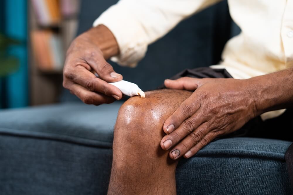 man applying ointment cream for joint knee pain